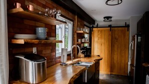 Een keuken met houten planken, een spoelbak en een koelkast.