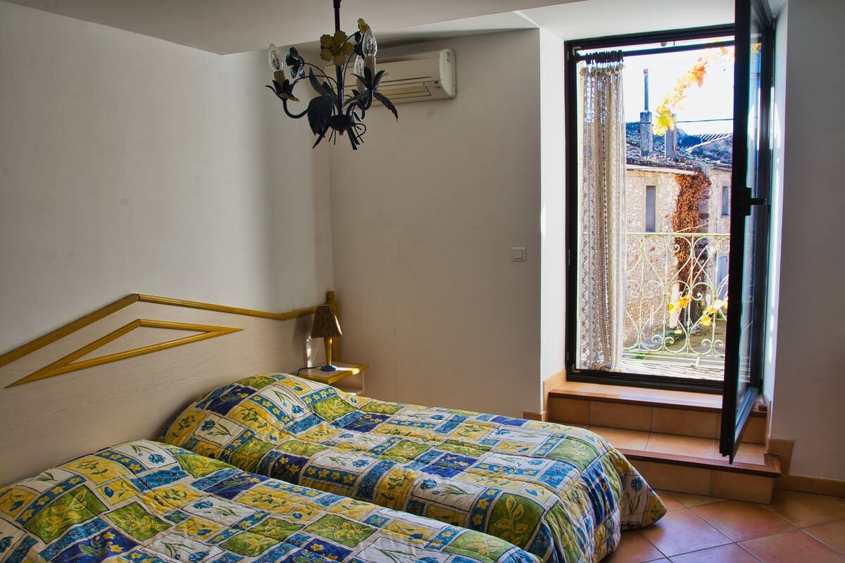 Un dormitorio con dos camas, un candelabro, aire acondicionado y vistas al exterior.