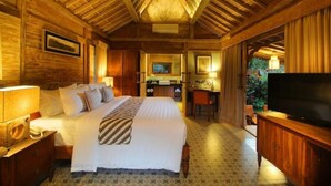 Hotelkamer met een groot bed, een bureau, een televisie en een badkamer die door een open deur zichtbaar is.