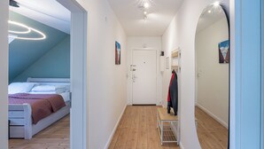 A bedroom with a bed, a bedside table, a mirror, and a door. - Bright & quiet, 200m to the subway (Ahrensburg)