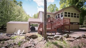 Ein zweistöckiges Haus mit einer Laube und einer Holztreppe.