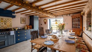 A dining area with a wooden table set for a meal, surrounded by chairs and a bench.