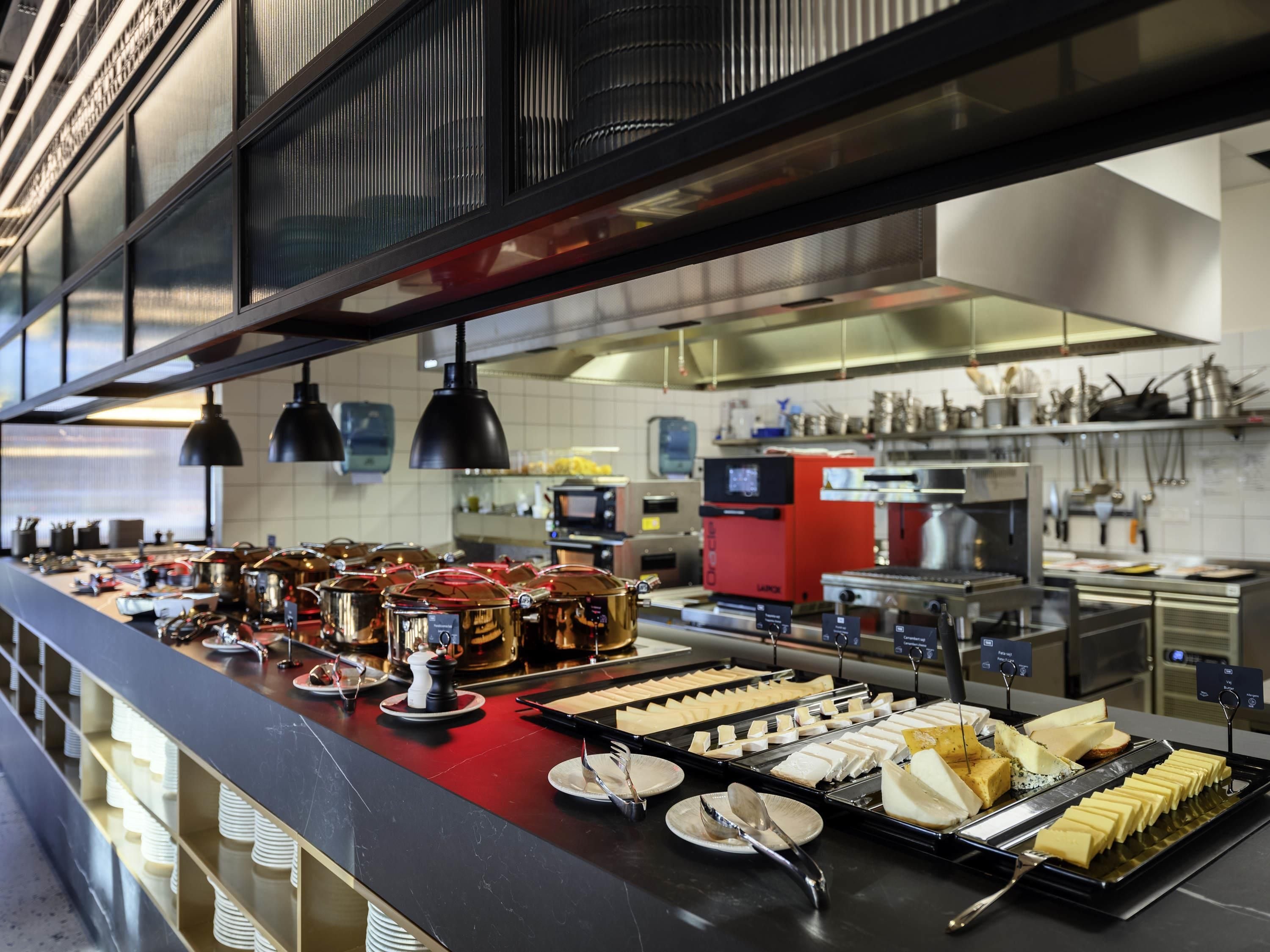A buffet with various food items and kitchen equipment in the background.