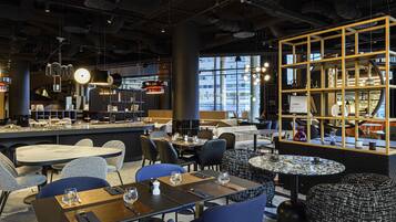 Un intérieur moderne avec des espaces aménagés pour s’asseoir, des tables et un présentoir.