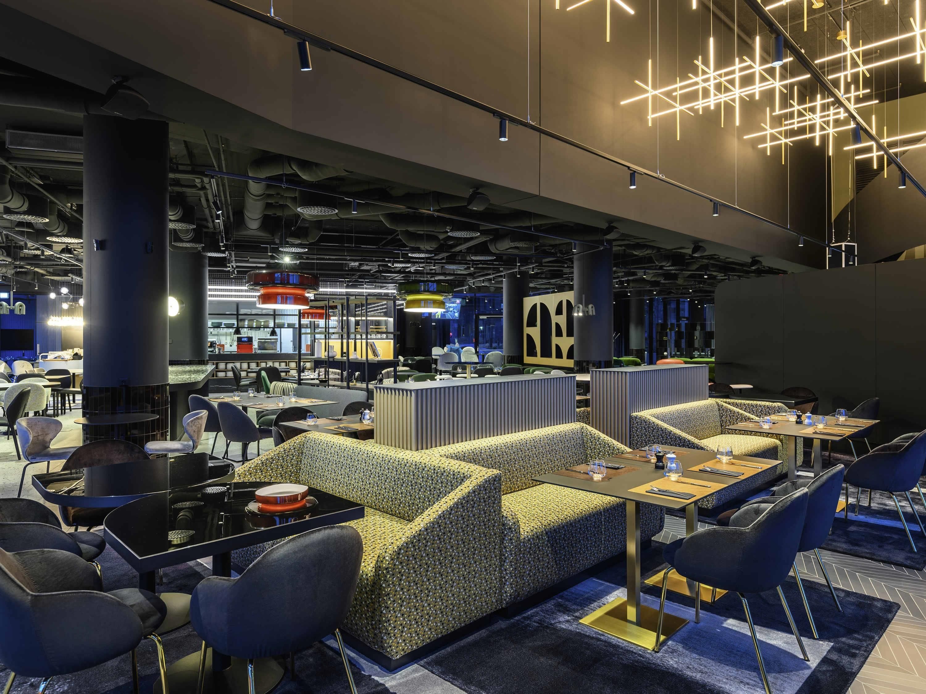 A modern dining area with booths, tables, and contemporary lighting fixtures.