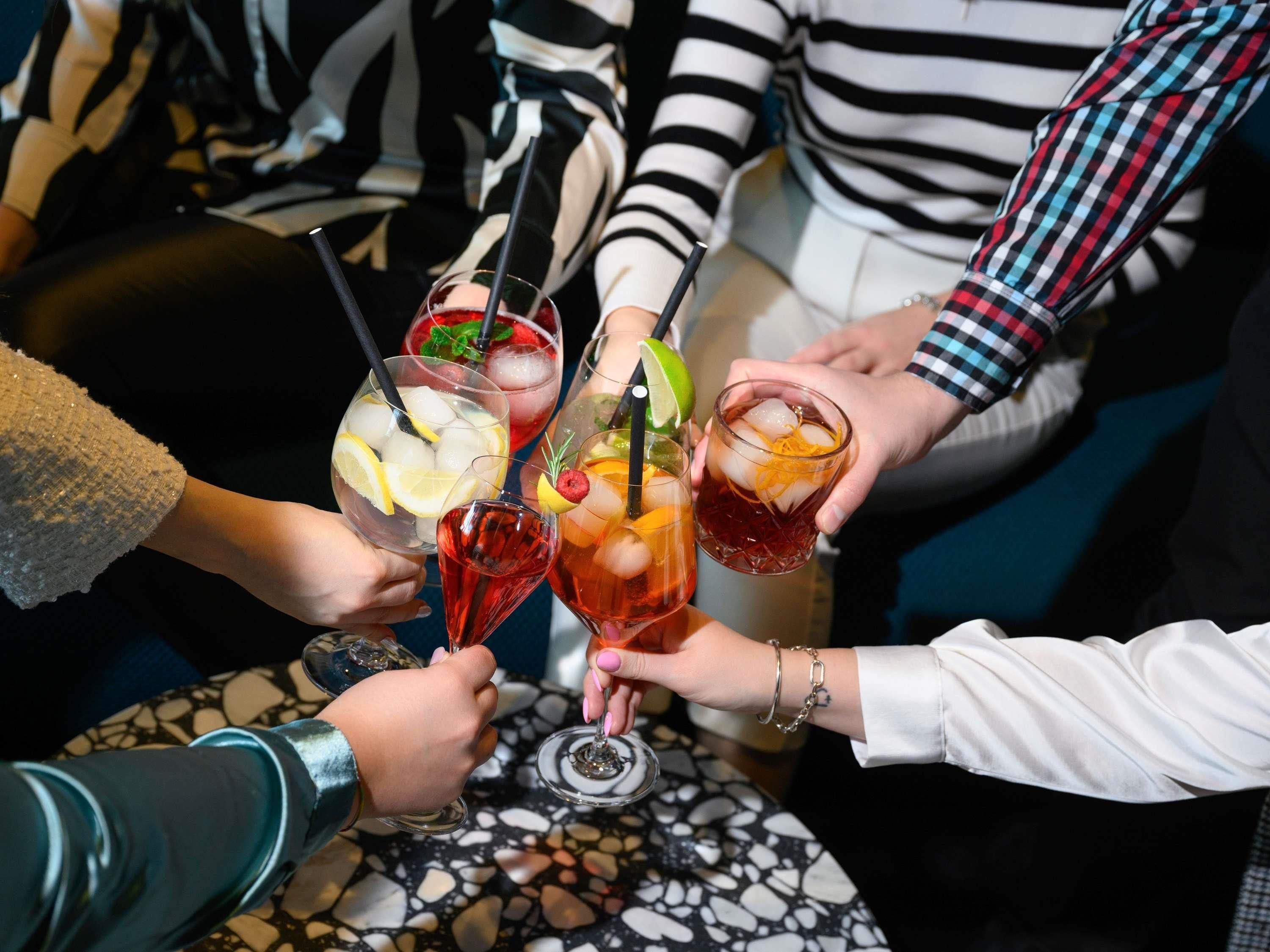 A group of people holding various drinks, possibly at a social gathering or event.