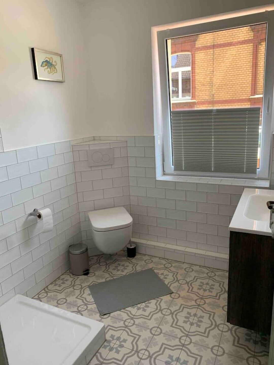 Une petite salle de bain avec des toilettes, un lavabo et une fenêtre.
