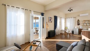 Un grand espace de vie comprenant un canapé, une table à manger et un coin cuisine.