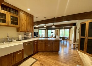 A spacious kitchen with wooden cabinets, a large island, and a dining area with a view.