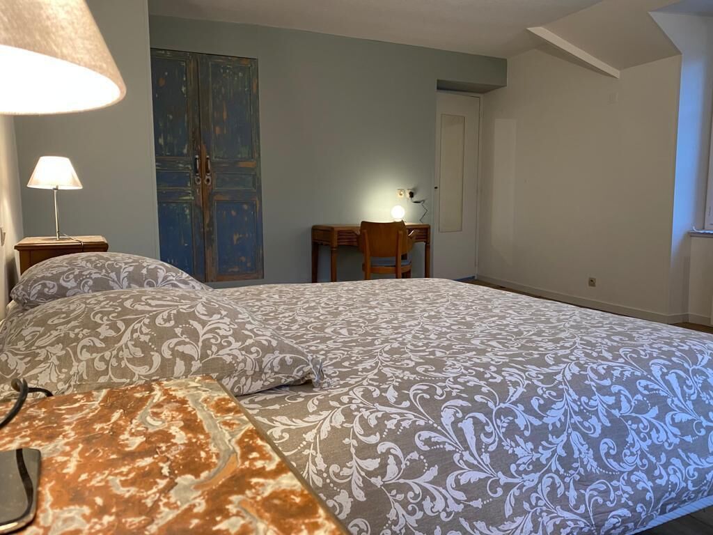 Un dormitorio con una cama, un escritorio y una silla.