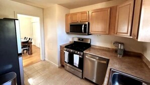 A kitchen with wooden cabinets, a stainless steel stove, a microwave, and a dishwasher. - Sunny Hilltop 2-BR Top Floor in Arlington (Arlington)