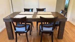 A dining table with four chairs, a framed picture on the wall, and a wooden floor. - Sunny Hilltop 2-BR Top Floor in Arlington (Arlington)