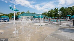 A water park with multiple water features, a covered seating area, and a pool. - Pickleball Dream - All New, Modern Condo in Sea Colony. 10mins walk to the beach (South Bethany)