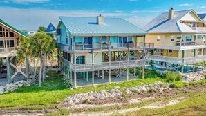 A coastal house with multiple decks, a swimming pool, and a beach view. - Just Like Heaven - Beachfront (Crawfordville)