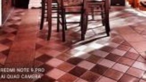 A dining area with wooden furniture and a checkered floor.