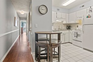 Enjoy cooking in this well-equipped kitchen with a stainless steel sink and refrigerator, plus a convenient dining area with a round table and stools.