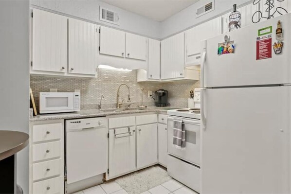 Effortlessly prepare meals in this well-equipped kitchen with a microwave, coffee maker, dishwasher, and oven.