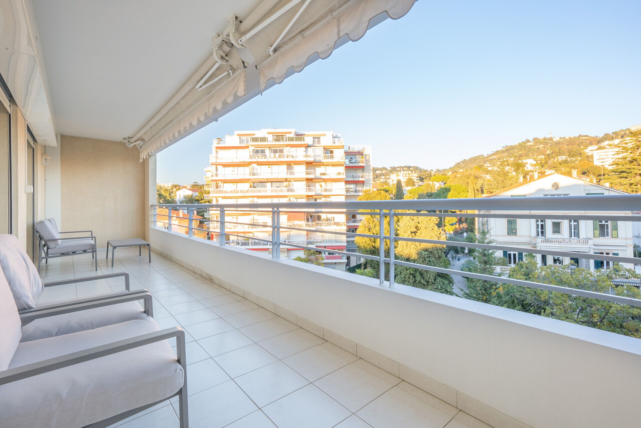 A balcony with a view of buildings and trees.