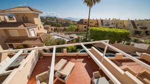 A rooftop terrace with outdoor furniture, a pool, and a view of surrounding buildings and landscape. - La Vizcarronda Rosemont 10.2 (Manilva)