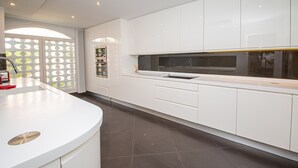 A modern kitchen with white cabinetry, a built-in oven, and a large window. - La Vizcarronda Rosemont 10.2 (Manilva)