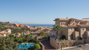 A coastal residential area with Mediterranean-style buildings, a swimming pool, and a view of the sea. - La Vizcarronda Rosemont 10.2 (Manilva)