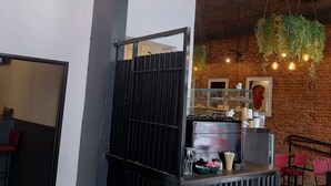 A modern interior with exposed brick walls, hanging pendant lights, a reception desk, and a visible sign reading "SH PALERMO SOHO". - Sweet Home Palermo Soho Hostel (Buenos Aires)