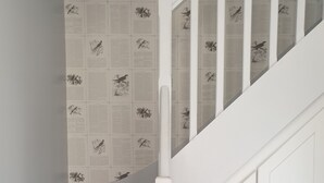 A staircase with white steps and a white railing, leading to a door with a handle.