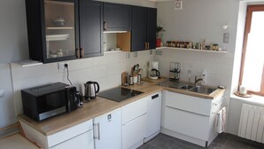 A compact kitchen with a microwave, coffee maker, and a sink.