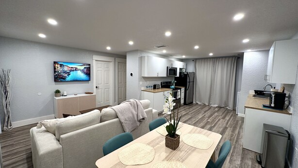 Een modern appartement met een woongedeelte, eetruimte en kitchenette.