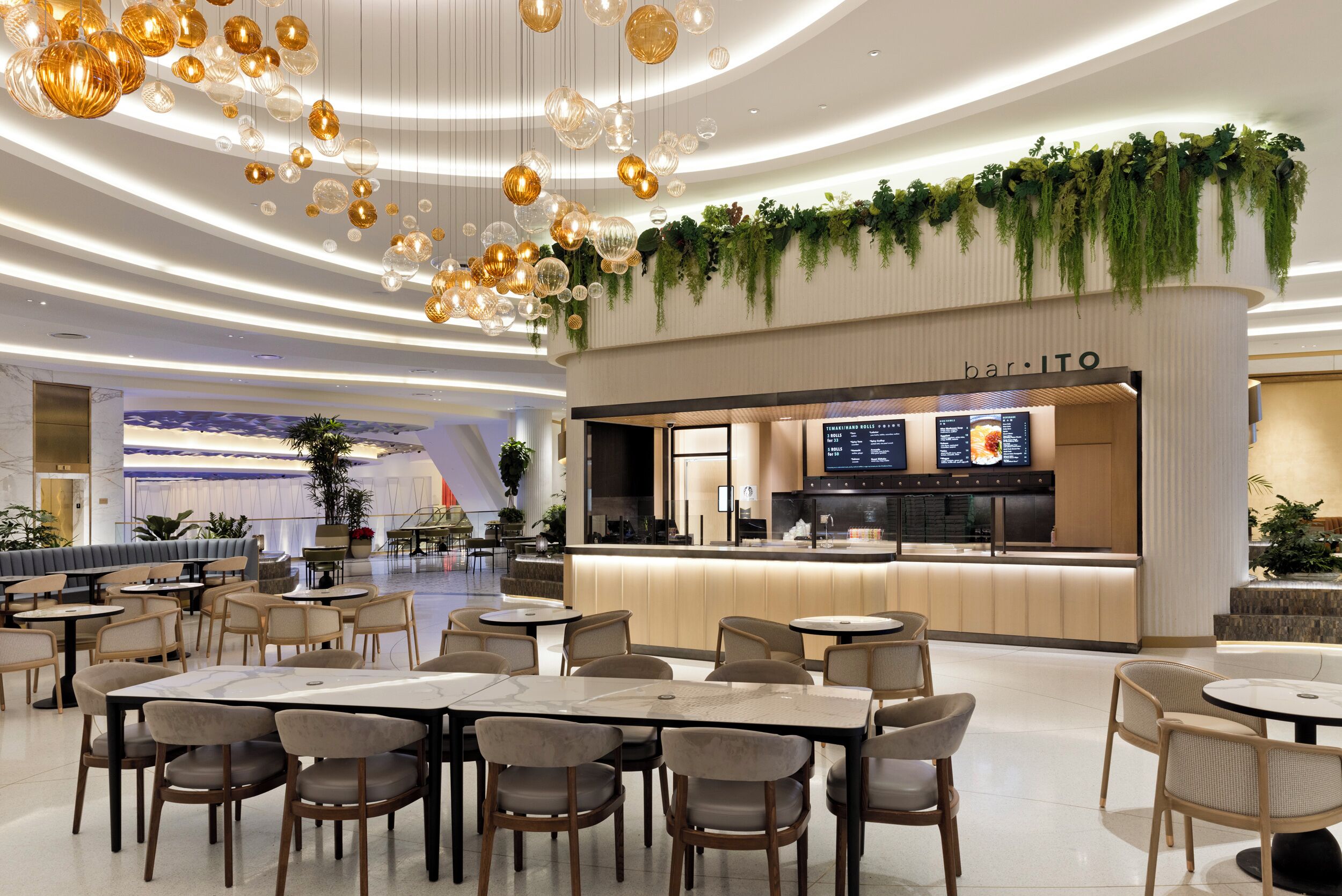A modern restaurant with a bar area, seating arrangements, and a digital menu display.