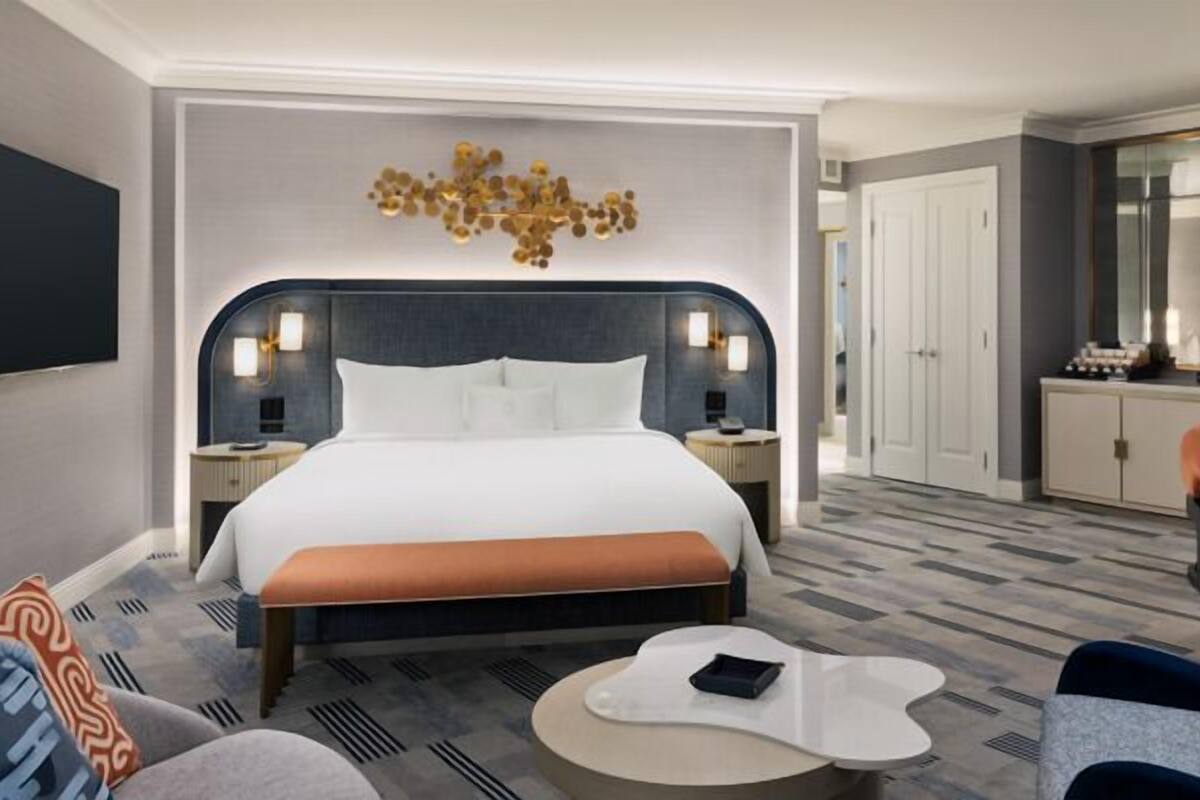 Une chambre d’hôtel moderne dotée d’un grand lit, d’un bureau et d’un coin salon.