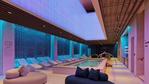 A modern spa area with a pool, seating, and a no diving sign.