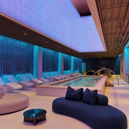 A modern spa area with a pool, seating, and a no diving sign.