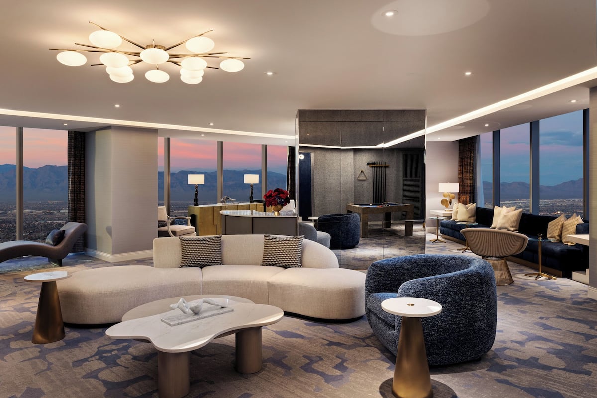Un hall d’hôtel moderne doté d’un grand espace salon, d’un bar et offrant une vue sur les montagnes.