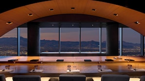 A restaurant with a panoramic city view, large windows, and a long dining table with chairs. - Fontainebleau Las Vegas, MICHELIN Key Award Hotel (Las Vegas)