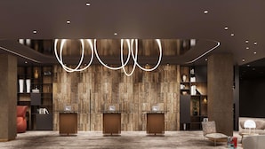 A modern reception area with a wooden wall, three counters, and a carpeted floor. - Pullman Okol Golf Resort and Spa (Opening winter 2026) (Samokov)