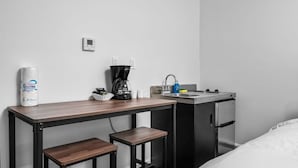 Una piccola cucina accessoriata con macchina del caffè, lavandino e frigorifero.