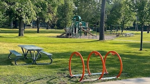 A park with a picnic table, playground equipment, and trees. - Two Queen Studio | 0.5 Miles to Beach + Near DT TC (Traverse City)