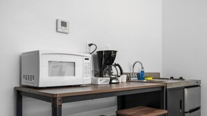 A kitchenette with a microwave, coffee maker, sink, and a small refrigerator. - Close to Beaches and Downtown (Traverse City)