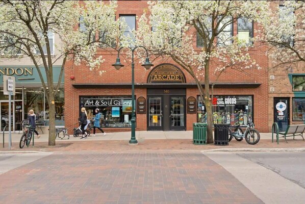 A brick building with storefronts including Arcade, Art & Soul Gallery, and Level Goods.