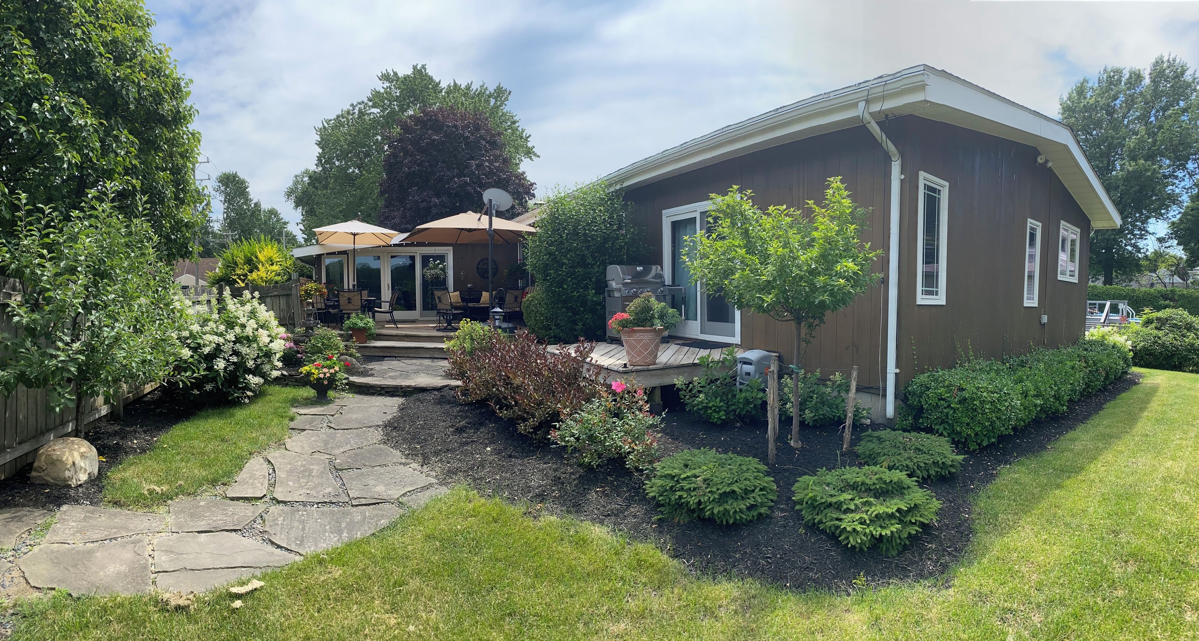Fenced in back yard with seasonally furnished wood deck. 