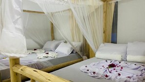 A room with two beds, each with a canopy and white bedding. - MKEKA SPICE LODGE (Jambiani)