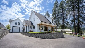 A two-story house with a garage, a covered porch, and a stone retaining wall.