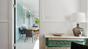 Une pièce avec une table et des chaises en bois, un banc décoratif et une lampe.
