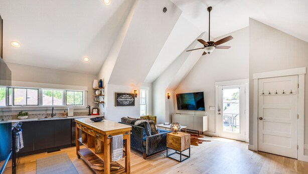 A spacious loft with a kitchen, living area, and a dining space. It features a high ceiling, a ceiling fan, and a large window providing natural light. - 14 Mi to Dtwn Denver: Sleek Westminster Home (Westminster)