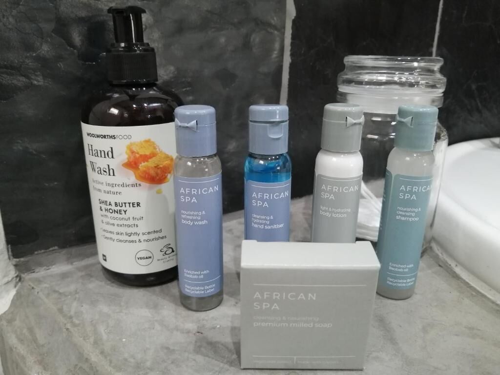 Estante de baño con diversos productos de higiene personal, como jabón de manos, loción corporal y champú.