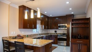 A modern kitchen with granite countertops, stainless steel appliances, and wooden cabinets.