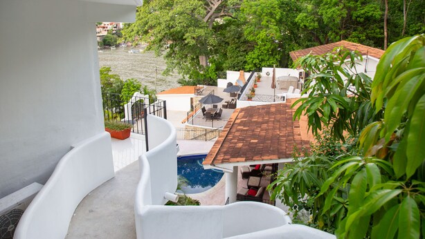 A residential area with a swimming pool, outdoor furniture, and lush greenery.