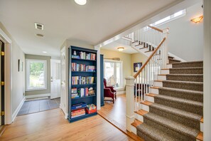 Step into this inviting space with a wooden floor, carpeted staircase, and a cozy reading nook.