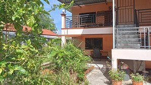 A two-story building with a balcony and a covered patio area. - Hidden Gems  (Thung Song)